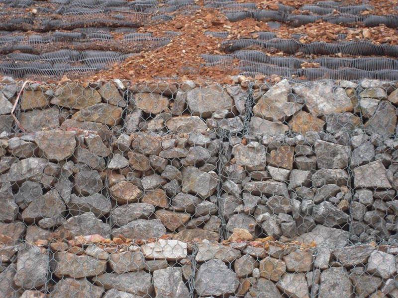 石籠網(wǎng)擋土墻，是石籠網(wǎng)籠子層疊堆砌的擋土建筑物